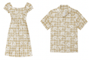 "Product flat lay of a matching beige and white Hibiscus Palaka set, featuring a women's square-neck puff-sleeve midi dress on the left and a men's short-sleeve button-down Aloha shirt on the right, both displaying a classic checkered pattern overlaid with white hibiscus floral motifs."