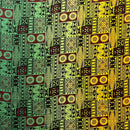 A flat-lay view of a Fijian Tapa Barkcloth Fabric (Style 3) featuring a traditional geometric pattern. The design consists of repeating rectangular tiles in a vibrant gradient of green, maroon, and yellow, filled with intricate black tribal motifs including sunbursts, triangles, and linear hatches.