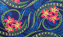 A flat-lay view of the Hibiscus, Plumeria Assortment Sarong (Style 1) featuring a vibrant Polynesian-inspired design. The pattern includes bright pink and yellow plumeria flowers set against a deep blue and teal background filled with intricate traditional tribal motifs, swirling ocean wave patterns, and geometric borders in lime green and white.