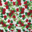 A repeating pattern of vibrant red poinsettias and green holly leaves with small red berries on a crisp white background.
