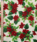 A repeating pattern of vibrant red poinsettias and green holly leaves with small red berries on a crisp white background. A ruler is placed across the center to show the scale of the print.