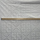 White on white foil fabric with a measuring stick 
