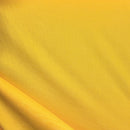 Solid gold rayon challis fabric draped in soft, spiral folds. 