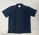 Black short-sleeve safari shirt with button-down front, dual chest pockets, and vertical pleat detailing.